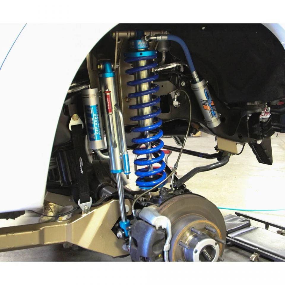Close-up of a vehicle's suspension system with blue springs and metal components.
